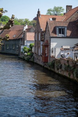 Bruges, Flanders, Belçika 'daki eski ortaçağ binalarının kanalı, köprüsü ve ön cepheleri güneşli bir günde gidilecek yer.
