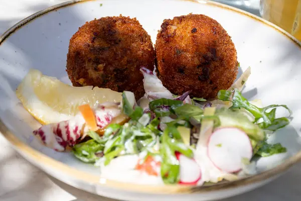 Açık kafede öğle yemeği. Vejetaryen peyniri ve yeşil kuşkonmaz kroket yanında taze salata ve Belçika, Bruges 'de patates kızartması.