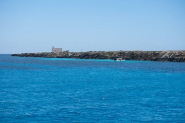 Trapani 'den tekne gezisi ve açık turkuvaz suyu, tuff kayaları, terk edilmiş taş ocakları, Sicilya, İtalya yakınlarındaki Egadi Adaları ile birlikte Favignana adasının kıyı şeridi manzarası.