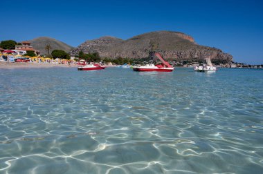 Deniz kenarında güneşli bir gün, Mondello Sahili, Sicilya 'da Palermo yakınlarında, güzel, altın kumu, turkuaz suları ve İtalya' nın güneyinde büyüleyici villaları olan.