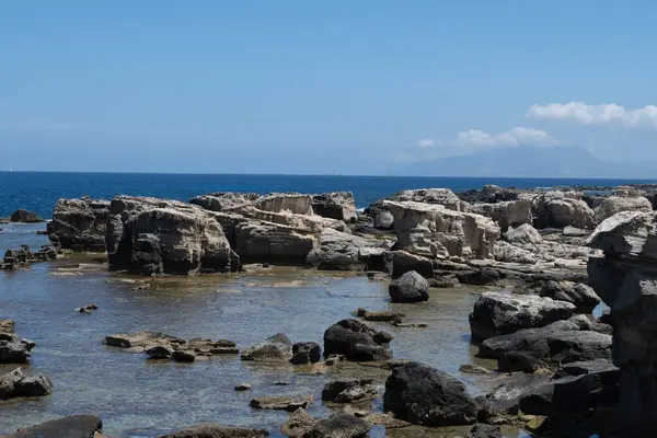 Favignana adasının kıyı şeridi, tuff kayaları, kültürel miras terk edilmiş taş ocakları, mağaralar, antik kalenit çıkarması, inşa için kullanılan taş, Sicilya, İtalya yakınlarındaki Egadi Adaları, tekne gezisi.