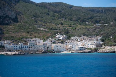 Levanzo, Egadi Adaları 'nın en küçüğü, Sicilya yakınlarında sakin bir inziva yeri, liman çevresindeki pitoresk köy, beyaz evler ve büyüleyici açık mavi su limanı, seyahat yeri, tekne gezisi.