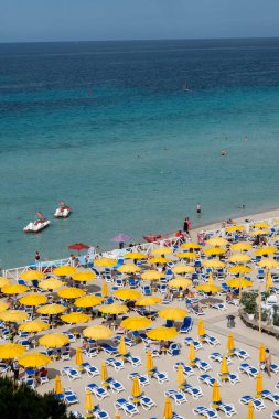 Güneşli bir gün, güneşli yataklarda ve şemsiyelerde Mondello Sahili 'nde, Sicilya' da Palermo yakınlarında, güzel, altın kumu, turkuaz suları ve büyüleyici villaları olan popüler sahil kenarı.