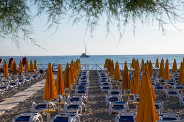 Güneşli bir gün, güneşli yataklarda ve şemsiyelerde Mondello Sahili 'nde, Sicilya' da Palermo yakınlarında, güzel, altın kumu, turkuaz suları ve büyüleyici villaları olan popüler sahil kenarı.