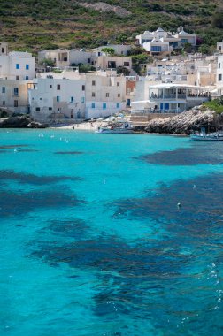 Levanzo, Egadi Adaları 'nın en küçüğü, Sicilya yakınlarında sakin bir inziva yeri, liman çevresindeki pitoresk köy, beyaz evler ve büyüleyici açık mavi su limanı, seyahat yeri, tekne gezisi.