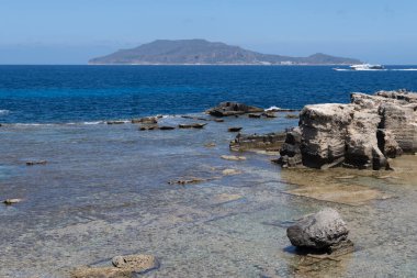 Favignana adasının kıyı şeridi, tuff kayaları, kültürel miras terk edilmiş taş ocakları, mağaralar, antik kalenit çıkarması, inşa için kullanılan taş, Sicilya, İtalya yakınlarındaki Egadi Adaları, tekne gezisi.