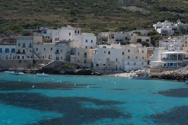 Levanzo, Egadi Adaları 'nın en küçüğü, Sicilya yakınlarında sakin bir inziva yeri, liman çevresindeki pitoresk köy, beyaz evler ve büyüleyici açık mavi su limanı, seyahat yeri, tekne gezisi.