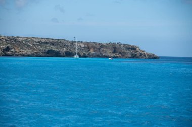 Trapani 'den tekne gezisi ve açık turkuvaz suyu, tuff kayaları, terk edilmiş taş ocakları, Sicilya, İtalya yakınlarındaki Egadi Adaları ile birlikte Favignana adasının kıyı şeridi manzarası.