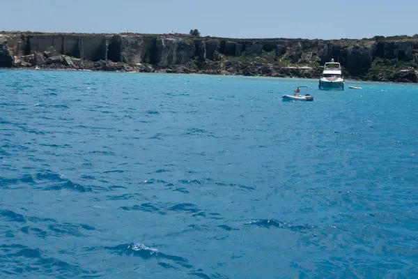 Trapani 'den tekne gezisi ve açık turkuvaz suyu, tuff kayaları, terk edilmiş taş ocakları, Sicilya, İtalya yakınlarındaki Egadi Adaları ile birlikte Favignana adasının kıyı şeridi manzarası.