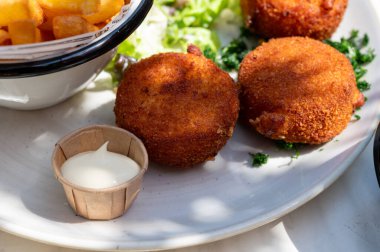 Açık kafede öğle yemeği. Vejetaryen peyniri ve yeşil kuşkonmaz kroket yanında taze salata ve Belçika, Bruges 'de patates kızartması.