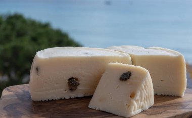 Primo İndirimli Sert Peynir. Karışık sütten yapılmış. Sicilya sepetinin ince kabuğu ve deseni turşulu kapari ve Sicilya, Mondello sahilinde deniz manzaralı.