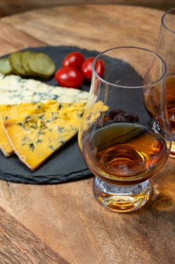 Viski ve peynir eşleşmesi, viski kadehleri ve dilimlenmiş eski mavi stilton ve mavi shropshire peynirleri, İngiltere 'nin yiyecek ve içeceği.
