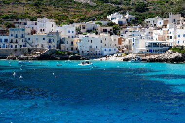 Levanzo, Egadi Adaları 'nın en küçüğü, Sicilya yakınlarında sakin bir inziva yeri, liman çevresindeki pitoresk köy, beyaz evler ve büyüleyici açık mavi su limanı, seyahat yeri, tekne gezisi.