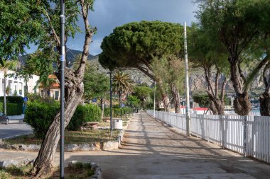 Deniz kenarındaki gezinti güvertesi, Mondello Sahili, Sicilya 'da Palermo yakınlarında, güzel, altın kumu, turkuaz suları, büyüleyici binaları ve villaları olan, İtalya' nın güneyi, tatil beldesi.