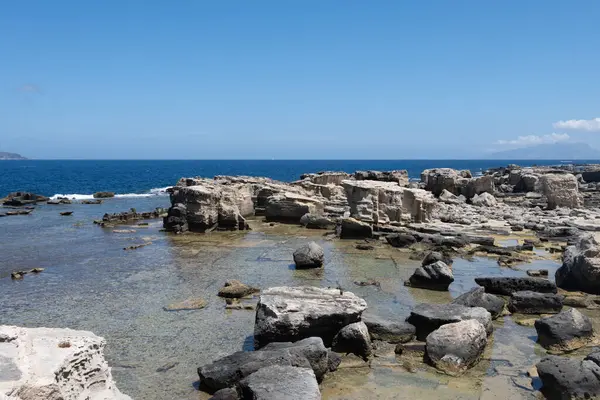 Favignana adasının kıyı şeridi, tuff kayaları, kültürel miras terk edilmiş taş ocakları, mağaralar, antik kalenit çıkarması, inşa için kullanılan taş, Sicilya, İtalya yakınlarındaki Egadi Adaları, tekne gezisi.