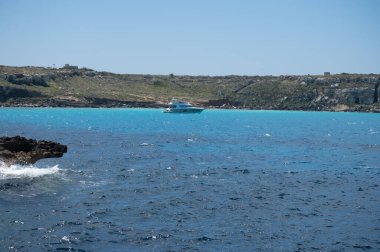 Trapani 'den tekne gezisi ve açık turkuvaz suyu, tuff kayaları, terk edilmiş taş ocakları, Sicilya, İtalya yakınlarındaki Egadi Adaları ile birlikte Favignana adasının kıyı şeridi manzarası.