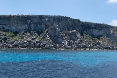 Favignana adasının kıyı şeridi, tuff kayaları, kültürel miras terk edilmiş taş ocakları, mağaralar, antik kalenit çıkarması, inşa için kullanılan taş, Sicilya, İtalya yakınlarındaki Egadi Adaları, tekne gezisi.