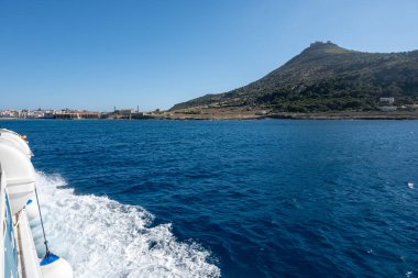 Trapani 'den tekne gezisi ve açık turkuvaz suyu, küçük bir köy, terk edilmiş taş ocakları, Sicilya, İtalya yakınlarındaki Egadi Adaları ile Favignana adasının kıyı şeridi manzarası.