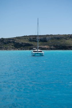 Trapani 'den tekne gezisi ve açık turkuvaz suyu, tuff kayaları, terk edilmiş taş ocakları, Sicilya, İtalya yakınlarındaki Egadi Adaları ile birlikte Favignana adasının kıyı şeridi manzarası.