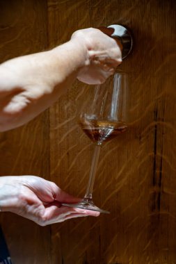 Eski büyük meşe fıçılarıyla şarap mahzenini ziyaret etmek, Marsala, Sicilya, İtalya ve şarap endüstrisindeki fıçılardan güçlendirilmiş veya tatlı marsala şarabı dökmek.