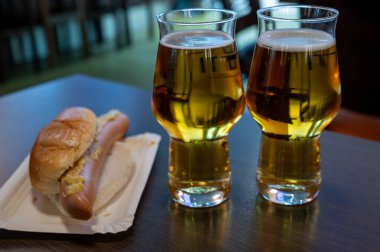 Taze demlenmiş hafif bira fıçıdan dökülen bira bardaklarıyla servis edilen bira fabrikasında Alman birasını deviriyor.