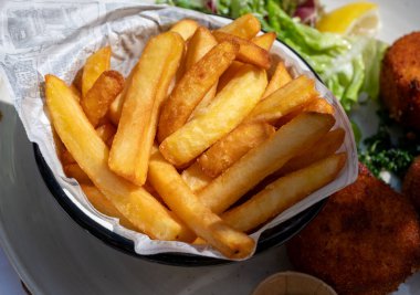 Açık kafede öğle yemeği. Vejetaryen peyniri ve yeşil kuşkonmaz kroket yanında taze salata ve Belçika, Bruges 'de patates kızartması.