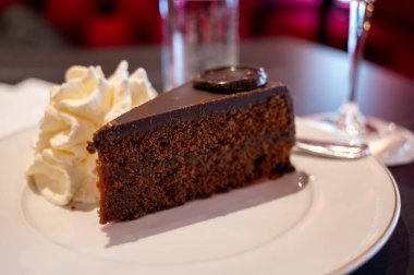 Avusturya kaynaklı kayısı reçelli ünlü Sachertorte çikolatalı keki Viyana 'daki eski klasik kafe restoranında kremayla servis ediliyor.