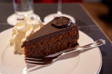 Avusturya kaynaklı kayısı reçelli ünlü Sachertorte çikolatalı keki Viyana 'daki eski klasik kafe restoranında kremayla servis ediliyor.