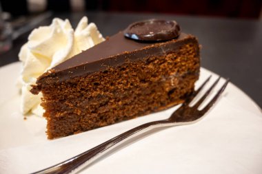 Avusturya kaynaklı kayısı reçelli ünlü Sachertorte çikolatalı keki Viyana 'daki eski klasik kafe restoranında kremayla servis ediliyor.