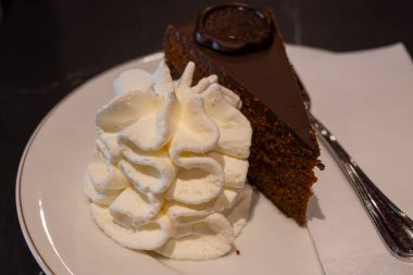 Avusturya kaynaklı kayısı reçelli ünlü Sachertorte çikolatalı keki Viyana 'daki eski klasik kafe restoranında kremayla servis ediliyor.