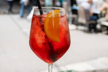 Spritz Campari, likör, şarap, buz küpleri ve bir parça portakal, Palermo, Sicilya, İtalya 'nın sokak manzaralı sert, uzun bir kokteyl kızı.