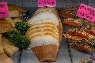 Oostende, Belçika 'da balık pazarında turistler için deniz ürünleri, çeşitli deniz kabukları, karides, yengeç çubukları, füme balık sergilenen plastik kutu.