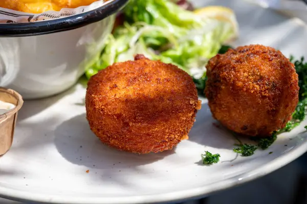 Açık kafede öğle yemeği. Vejetaryen peyniri ve yeşil kuşkonmaz kroket yanında taze salata ve Belçika, Bruges 'de patates kızartması.