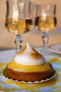 Bir Fransız limonlu turta ya da beyaz yumurtalı turta ve şampanyalı bardak köpüklü şarap, lezzetli tatlı, Fransız mutfağı.