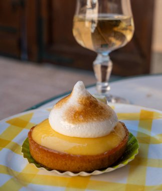 Bir Fransız limonlu turta ya da beyaz yumurtalı turta ve şampanyalı bardak köpüklü şarap, lezzetli tatlı, Fransız mutfağı.