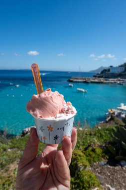 Levanza adasının mavi körfezi manzaralı taze dondurma yemek Sicilya, İtalya yakınlarındaki Egadi 'de mutlu yaz tatilleri.