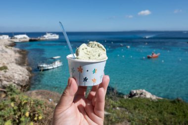 Levanza adasının mavi körfezi manzaralı taze dondurma yemek Sicilya, İtalya yakınlarındaki Egadi 'de mutlu yaz tatilleri.