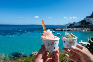 Levanza adasının mavi körfezi manzaralı taze dondurma yemek Sicilya, İtalya yakınlarındaki Egadi 'de mutlu yaz tatilleri.
