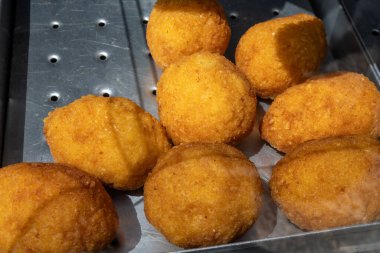 Arancini Sicilya usulü, risotto ile kızartılmış pirinç topları, mozzarella, ragu, bezelye, kızarmış ekmek kırıntılarıyla kaplı, İtalya, Sicilya, Palermo 'da kahverengi