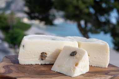 Primo İndirimli Sert Peynir. Karışık sütten yapılmış. Sicilya sepetinin ince kabuğu ve deseni turşulu kapari ve Sicilya, Mondello sahilinde deniz manzaralı.