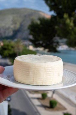 Primo İndirimli Sert Peynir. Karışık sütten yapılmış. Sicilya sepetinin ince kabuğu ve deseni turşulu kapari ve Sicilya, Mondello sahilinde deniz manzaralı.