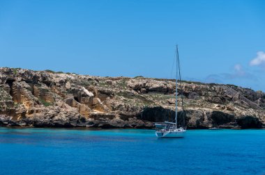 Trapani 'den tekne gezisi ve açık turkuvaz suyu, tuff kayaları, terk edilmiş taş ocakları, Sicilya, İtalya yakınlarındaki Egadi Adaları ile birlikte Favignana adasının kıyı şeridi manzarası.