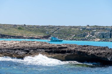 Trapani 'den tekne gezisi ve açık turkuvaz suyu, tuff kayaları, terk edilmiş taş ocakları, Sicilya, İtalya yakınlarındaki Egadi Adaları ile birlikte Favignana adasının kıyı şeridi manzarası.