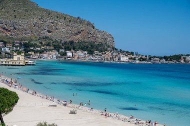 Deniz kenarında güneşli bir gün, Mondello Sahili, Sicilya 'da Palermo yakınlarında, güzel, altın kumu, turkuaz suları ve İtalya' nın güneyinde büyüleyici villaları olan.