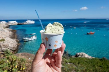 Levanza adasının mavi körfezi manzaralı taze dondurma yemek Sicilya, İtalya yakınlarındaki Egadi 'de mutlu yaz tatilleri.
