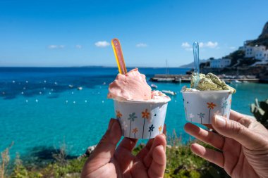 Levanza adasının mavi körfezi manzaralı taze dondurma yemek Sicilya, İtalya yakınlarındaki Egadi 'de mutlu yaz tatilleri.