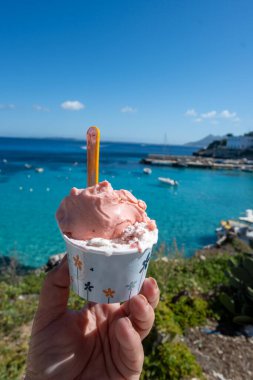 Levanza adasının mavi körfezi manzaralı taze dondurma yemek Sicilya, İtalya yakınlarındaki Egadi 'de mutlu yaz tatilleri.