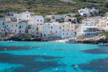 Levanzo, Egadi Adaları 'nın en küçüğü, Sicilya yakınlarında sakin bir inziva yeri, liman çevresindeki pitoresk köy, beyaz evler ve büyüleyici açık mavi su limanı, seyahat yeri, tekne gezisi.