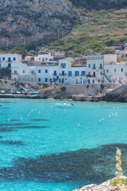 Levanzo, Egadi Adaları 'nın en küçüğü, Sicilya yakınlarında sakin bir inziva yeri, liman çevresindeki pitoresk köy, beyaz evler ve büyüleyici açık mavi su limanı, seyahat yeri, tekne gezisi.