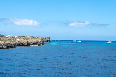 Trapani 'den tekne gezisi ve açık turkuvaz suyu, tuff kayaları, terk edilmiş taş ocakları, Sicilya, İtalya yakınlarındaki Egadi Adaları ile birlikte Favignana adasının kıyı şeridi manzarası.